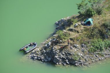Aerial view of a fisherman and his rubber dinghy and his bivouac in the Uvac Special Nature Reserve near Sjenica in Serbia clipart