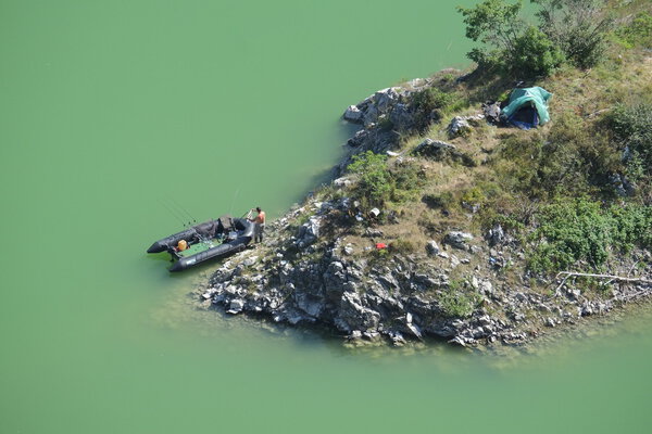 Вид с воздуха на рыбака и его резиновую шлюпку и бивуак в Специальном природном заповеднике Увац близ Шеницы в Сербии
