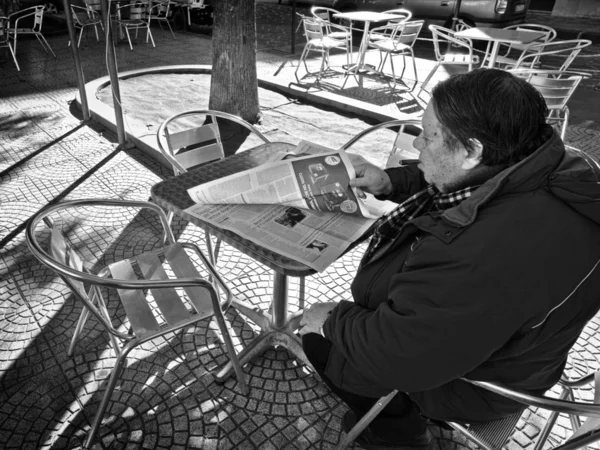 Een man met een sigaar zit in een buitencafé en is het lezen van een krant — Stockfoto