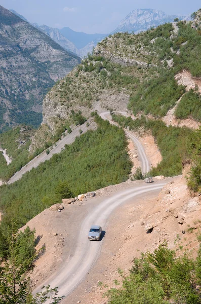 Coche, camino sinuoso y montañas albanesas — Foto de Stock