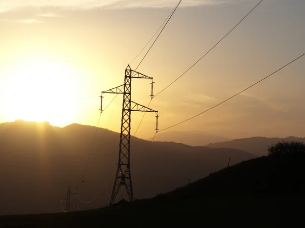 Pilão de eletricidade ao pôr do sol — Fotografia de Stock