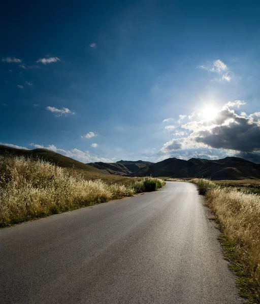 Arkadan aydınlatmalı ülkede yol asfalt — Stok fotoğraf