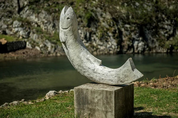 A estátua em forma de peixe na margem do rio — Fotografia de Stock