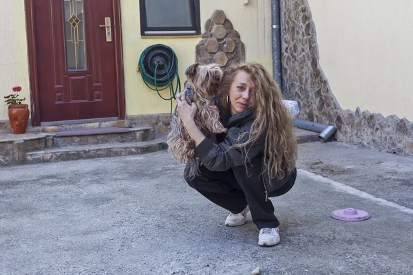 Dame mit einem flauschigen Hund im Hinterhof — Stockfoto
