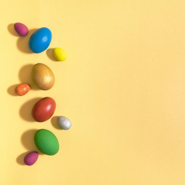 Sarı arka planda renkli paskalya yumurtaları düzleşmişti.