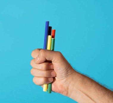 Bir adamın eli, olimpiyat renklerinde keçeli kalemden yapılmış bir meşaleyi tutuyor. En az yaratıcı olimpiyat oyunları konsepti