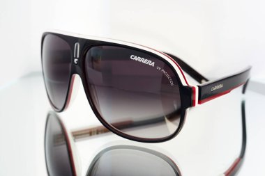 Siyah ve kırmızı çerçeveli kahverengi renkli büyük yuvarlak güneş gözlükleri..