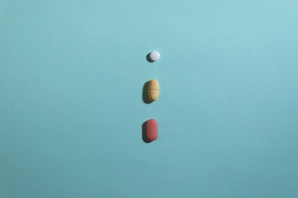 Mavi arka planda beyaz, kırmızı ve sarı haplar.