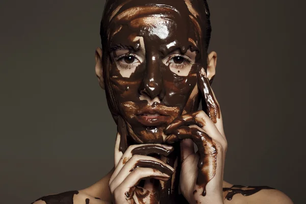Frau mit Schokolade übergossen Stockbild