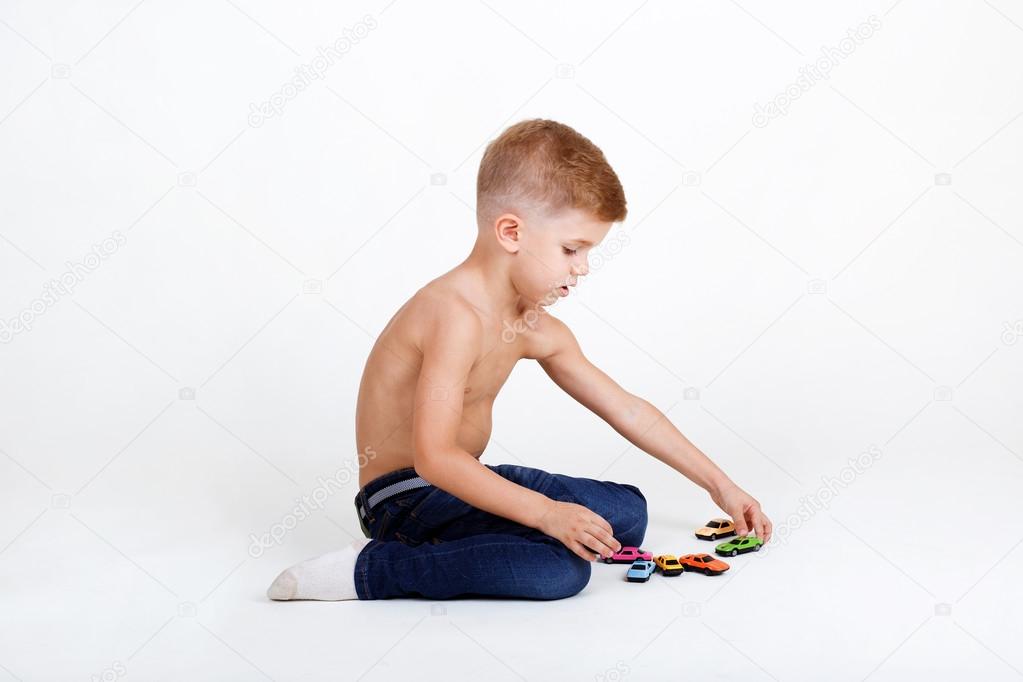 little boy plays with toy cars