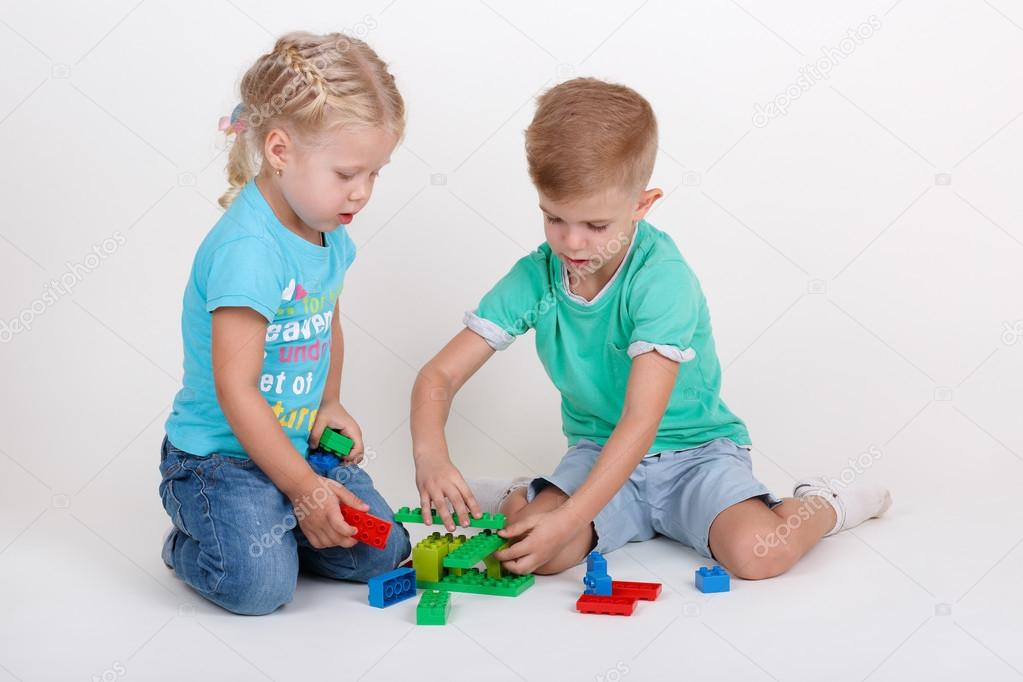 boy and girl playing with plastic blocks
