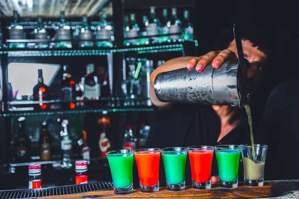 Uzman barmen gece kulübü ya da bar kokteyl yapıyor. Bardak ateşli kokteyl çubuğu arka planı barmenler el ateşle karşı. Barmen gün kavramı
