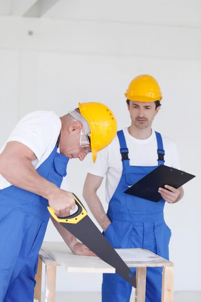 Trabajador aserrado tablero de madera — Foto de Stock