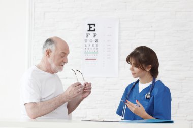 Doktor yeni gözlük için görüş testi yapıyor.