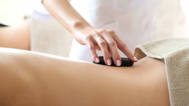 Женщине делают каменный массаж в спа — стоковое видео