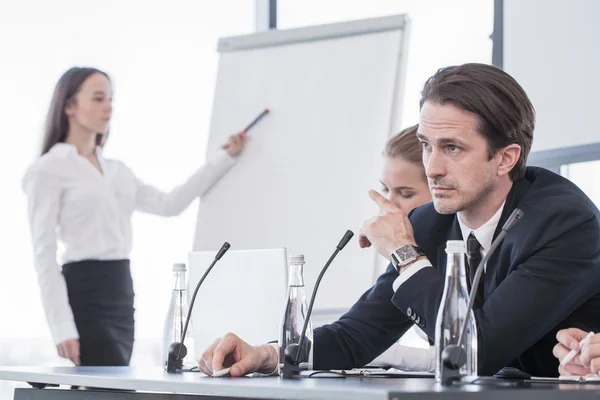 Femme d'affaires parlant à la présentation et pointant vers le tableau blanc — Photo