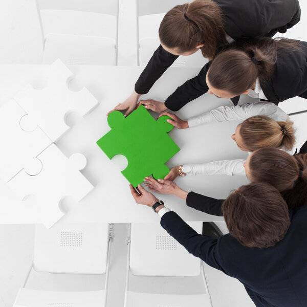 Business people assembling puzzle