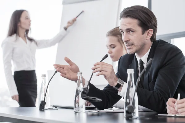 Business people speaking at presentation in microphone in office — Stock Photo, Image