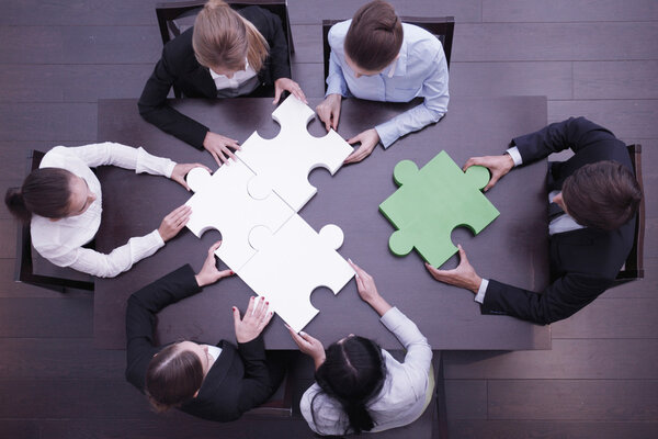 Business people assembling puzzle 