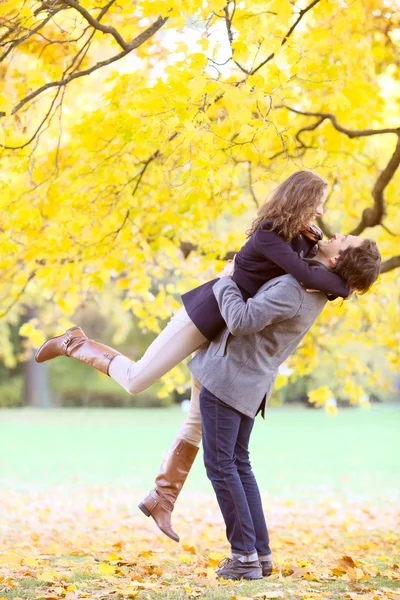 夫妇在片秋色的公园中拥抱 — 图库照片