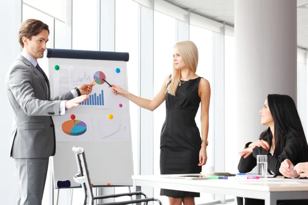 Lavoratori in riunione d'affari guardando la presentazione di relazioni finanziarie in ufficio moderno — Foto Stock