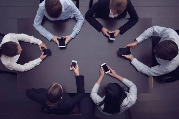 Empresários Com Telefones Inteligentes Sentados Torno Mesa Vista Superior — Fotografia de Stock