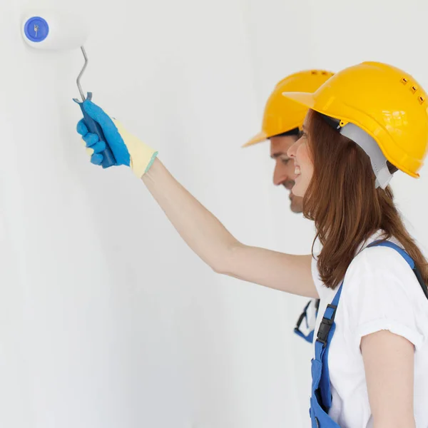 Dois Jovens Trabalhadores Uniforme Macacão Hardhat Pintura Parede Branca — Fotografia de Stock