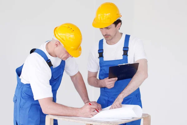 Trabalhadores Uniforme Azul Chapéus Amarelos Com Planta Que Trabalha Canteiro — Fotografia de Stock