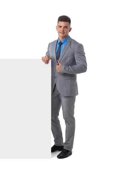白い背景に隔離されたバナーホワイトボードのサインを示すスーツの若い男の完全な長さの肖像画 — ストック写真