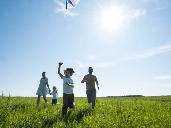 父母和孩子们带着风筝在暑假 完美的草地和海滨的天空中奔跑 — 图库照片