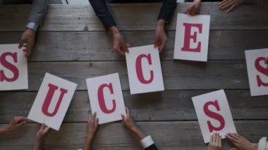 Çok ırklı çeşitli insanlardan oluşan bir grup harfleri birleştirerek başarılı takım çalışması işbirliği kavramını oluşturdu.