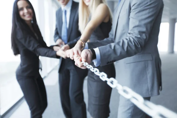 Businessmen pulling chain — Stock Photo, Image