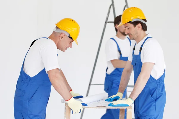 Workmen looking at house design — Stock Photo, Image