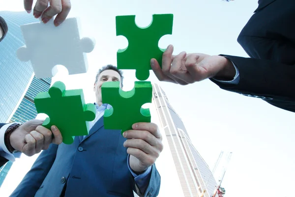 Business people assembling jigsaw puzzle — Stock Photo, Image