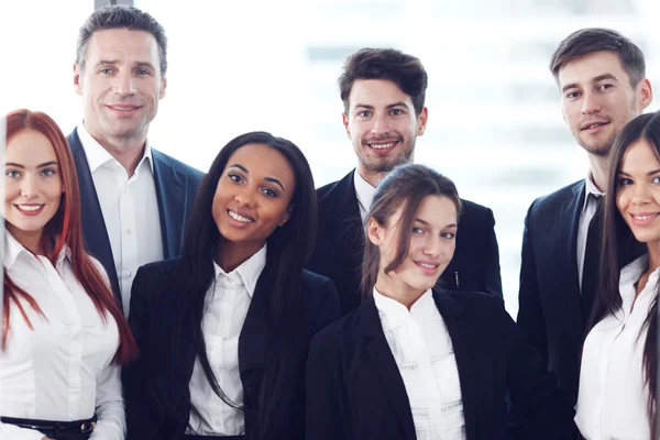 Portret van zakenteam van mannen en vrouwen in functie met zicht op wolkenkrabbers — Stockfoto