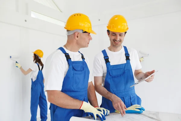 Jonge vriendelijke arbeider met tools geïsoleerd op witte achtergrond — Stockfoto