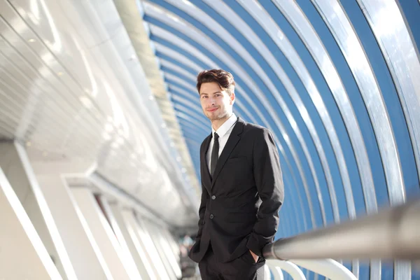 Joven Empresario de pie en el pasillo del moderno edificio de oficinas — Foto de Stock