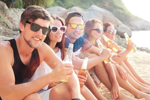 Friends drinking beer on beach — Stock Photo, Image