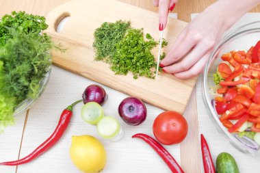 Kadınların elleri kıyılmış yeşillikleri.