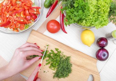 Kadınların elleri kıyılmış yeşillikleri.