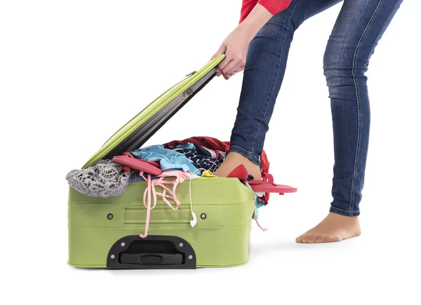 Kobieta stąpający popycha rzeczy w walizce. — Zdjęcie stockowe