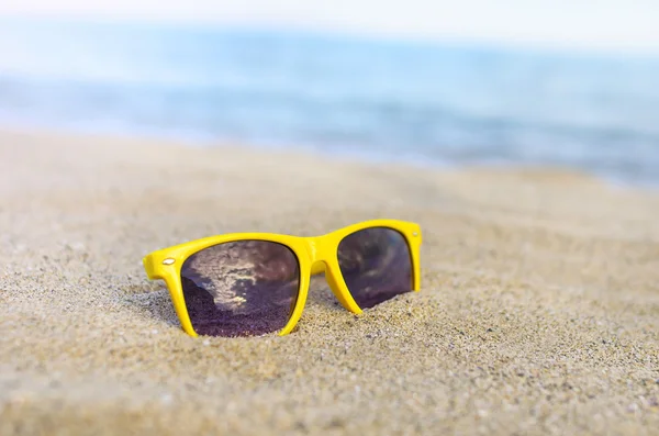 Solglasögon stranden mot bakgrund av havet. — Stockfoto