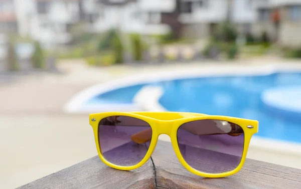 Solglasögon på en bakgrund av poolen. — Stockfoto