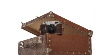 Beyaz arka planda eski bavul ve eski kamera.