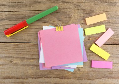 Eski ahşap masa üstünde defter etrafında renkli çıkartmalar