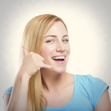 Telefon işareti işaret ve gülümseyen sarışın. Beyaz izole.
