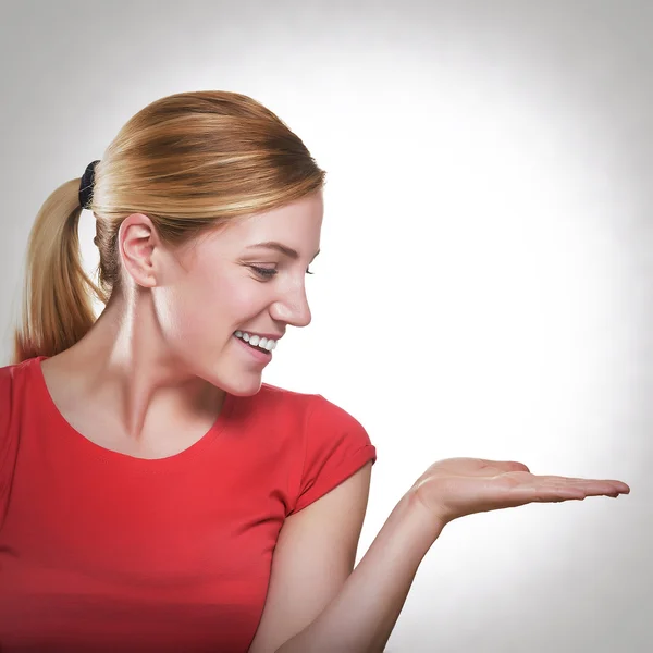 Blonde woman showing a product — Stok fotoğraf