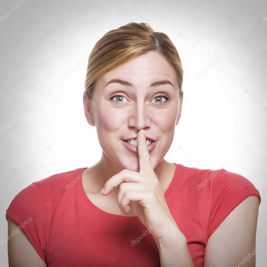 Blonde holding a finger to her mouth. 