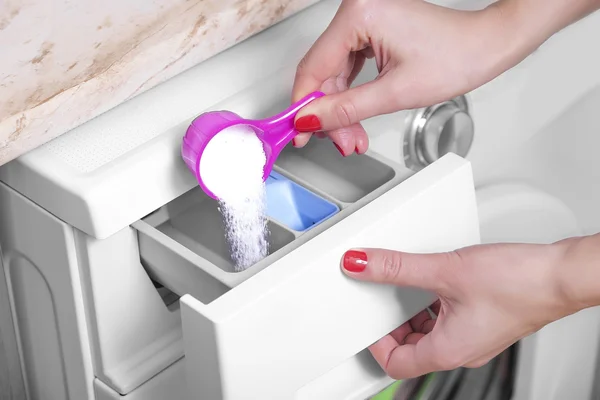 Woman throws laundry detergent into the washing machine. — Stock Photo, Image