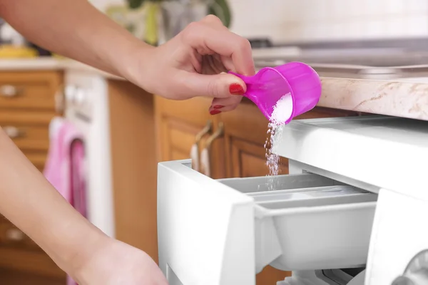 Woman throws laundry detergent into the washing machine. — Stock Photo, Image